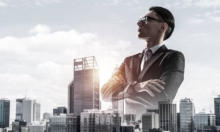 Double exposure of elegant businessman and modern busines city with towers and skyscrapersの写真素材