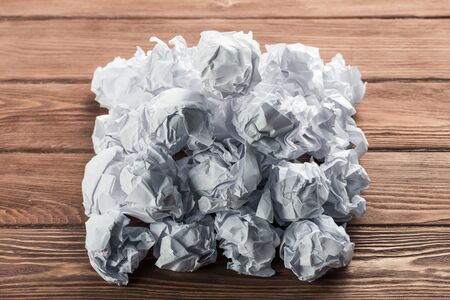 White crumpled up piece of paper on wooden table as ideaの写真素材