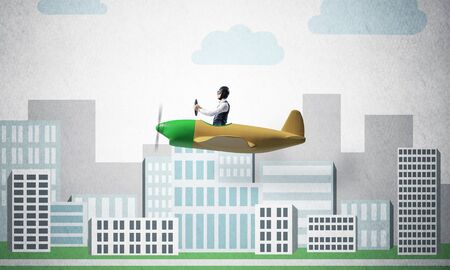 Aircraft pilot sitting in small propeller plane and holding steering wheel. Aviator driving retro airplane on background of city illustration. Cityscape with high skyscrapers and office buildings.の写真素材