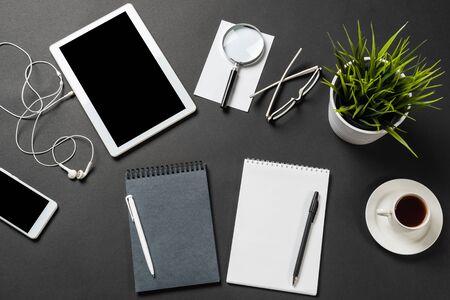 Top view of modern workplace with tablet computer. Flat lay composition with green plant in pot and...