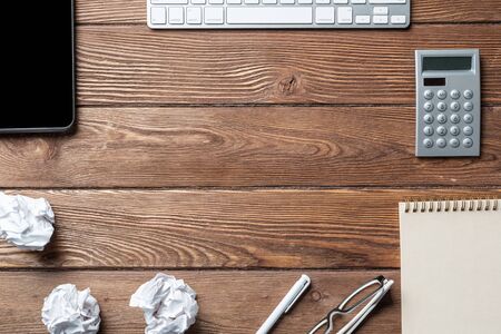 Still life of accountant workspace with office accessories. Flat lay wooden desk with keyboard,...