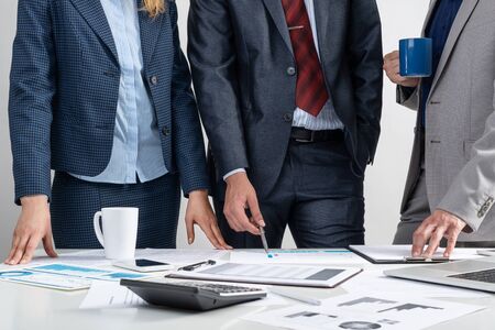 Corporate teamwork concept with businessmen. Office desk with financial charts. Business meeting time in conference hall. Presentation and discussion of new startup project. Business partnershipの写真素材