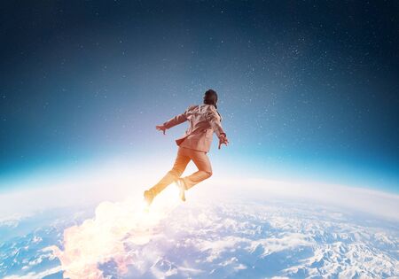 Businessman in suit and aviator hat flying in blue sky as superhero. Corporate manager  launching...