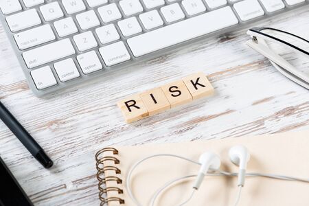 Risk management concept with letters on cubes. Still life of office workplace with supplies. Flat...