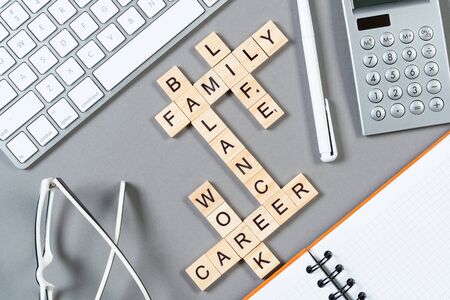 Business motivation concept with words from cubes. Still life of office workplace with crossword. Flat lay grey surface with computer keyboard and calculator. Strategy planning and business analytics.の写真素材