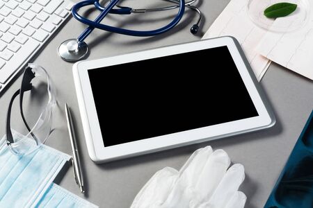High angle shot of tablet and medical items on gray surfaceの写真素材
