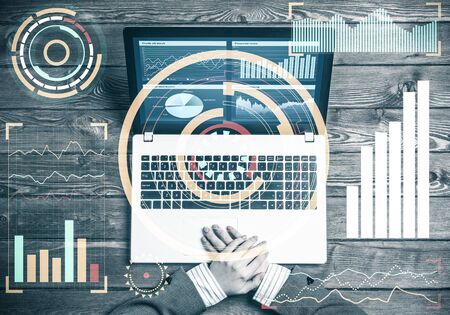 Top view of businesswoman sitting at wooden table with laptopの写真素材