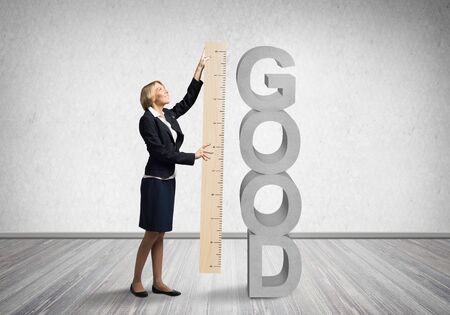 Woman holding big ruler on wall background. Business development to success. Businesswoman measuring something with ruler. Human resources recruitment. Creative motivation, coaching and mentoring.の写真素材