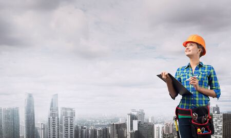 Engineer woman with folder on modern city landscapeの写真素材