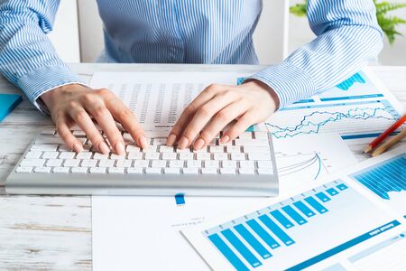 Manager typing on computer keyboard at wooden desk. Strategy planning and banking. Financial analyst...