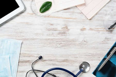 Medical diagnostics in modern hospital. Top view of doctor desk with x-ray image, stethoscope and cardiogram. Rehabilitation therapy concept. Professional healthcare and medical insurance serviceの写真素材