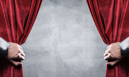 Close up of businessman hand open red velvet curtain. Place your textの写真素材