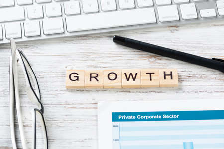 Financial growth concept with letters on cubes. Still life of office workplace with supplies. Flat...