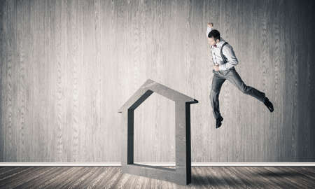 Determined businessman going to break with fist house concrete figureの写真素材