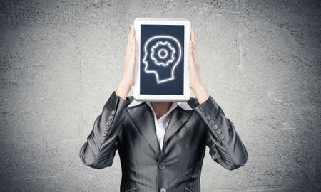 Portrait of woman covering her face with tablet computer. Businesswoman showing tablet PC with human...