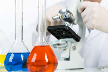 Scientist looking through microscope in laboratory. Biotechnology industry, research and...