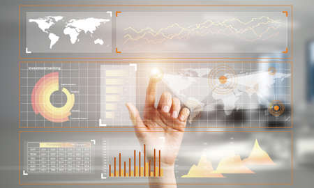 Hand of woman working with media interface on screen and office interior at background