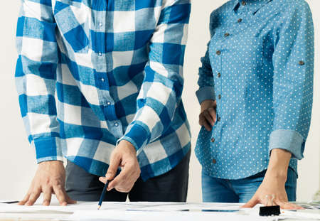 Design project discussing in architecture studio. Architect analyzing paper blueprint. Close up man...