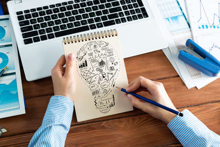 close-up, woman draws business notes in her notebook. Business Innovation Conceptの写真素材