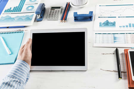 close-up of mens hands with a computer tablet. Businessman works in the office