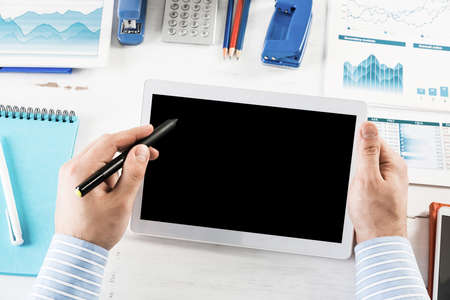 close-up of mens hands with a computer tablet. Businessman works in the office
