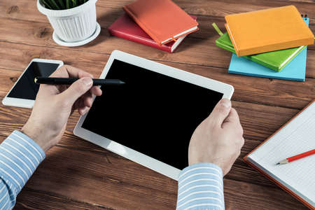 close-up of mens hands with a computer tablet. Businessman works in the officeの写真素材