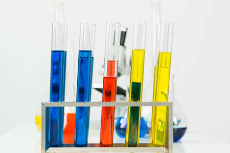 School chemical laboratory with glassware and microscope. Test tubes and flasks with color liquid standing on desk. School education and microbiology experiments mockup. Science laboratory researchの写真素材