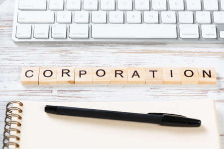 Corporation concept with letters on cubes. Still life of office workplace. Flat lay vintage wooden...
