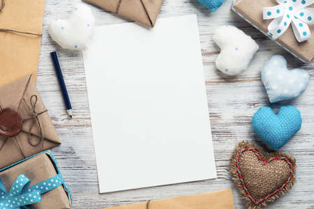 Flat lay composition with fabric love hearts and ribbon. Blank sheet of white paper on vintage wooden table. Declaration of love letter. Saint Valentines day congratulation. Romantic event invitationの写真素材