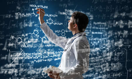 young scientist works with scientific formulas. mixed mediaの写真素材