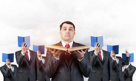Senior businessman holding old open book. Man in business suit and tie standing on cityscape...
