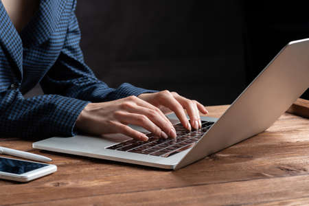 Business lady typing on laptop computer at wooden desk. Strategy planning and banking. Financial...