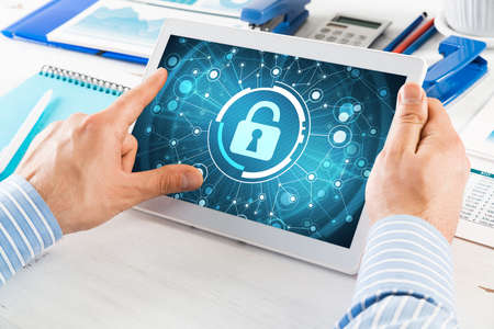 close-up, male hands with tablet. Businessman working at the table in office. computer security...