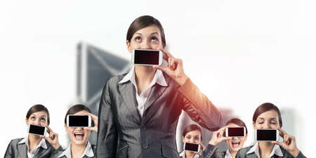 Business woman closes her mouth and eyes with a mobile phone. Business conceptの写真素材