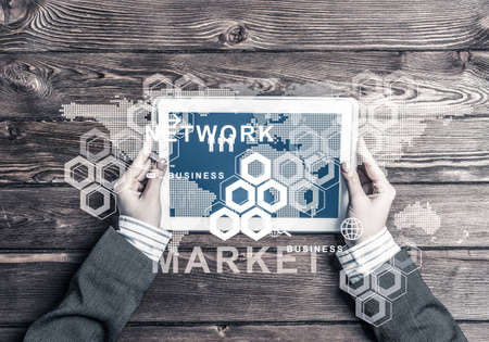 Top view of businesswoman sitting at wooden table with tablet pcの写真素材