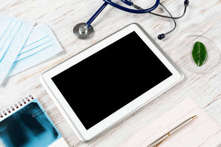 Medical diagnostics in modern hospital. Top view tablet computer with blank screen, x-ray image,...