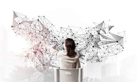 Businesswoman finger pointing on abstract network structure. Back view long haired woman in white suit sitting on white chair. Social connection and networking. Global cloud technology conceptの写真素材