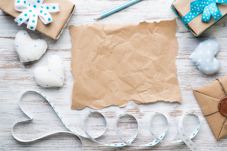 Flat lay vintage composition with fabric hearts. Brown wrapping paper on wooden table. Happy birthday or anniversary congratulation. Saint Valentines day holiday. Romantic scrapbooking wallpaper.の写真素材