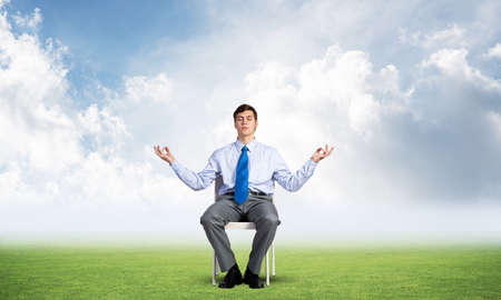 businessman sitting on an office chair, meditation and calmnessの写真素材