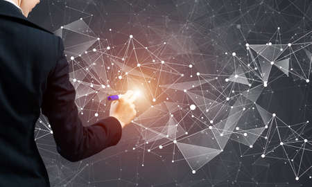 Businesswoman pointing on abstract 3d network. Back view of woman in business suit on dark...