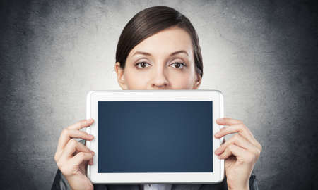 Businesswoman holding tablet computer with blank screen.