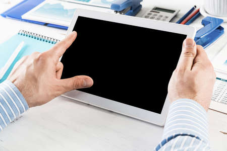 close-up of mens hands with a computer tablet. Businessman works in the office