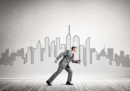 Young handsome businessman wearing white paper crown running in a hurryの写真素材