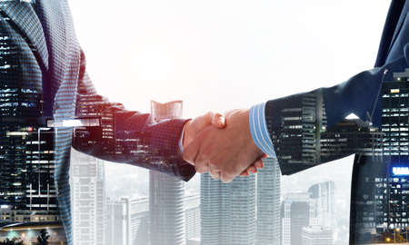 Close-up of the handshake of businessmen. Against the backdrop of the cityscape