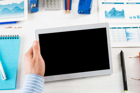 close-up of mens hands with a computer tablet. Businessman works in the officeの写真素材