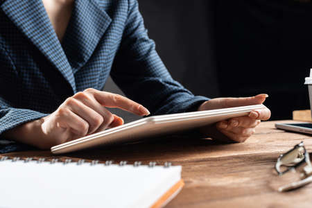 Businesswoman using tablet computer at desk. Close up woman hand pointing on touchscreen. Online stock trading and financial analytics. Digital technology in strategy planning and company managementの写真素材