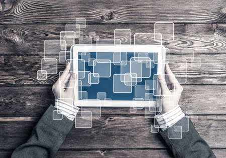Top view of businesswoman sitting at wooden table with tablet pc