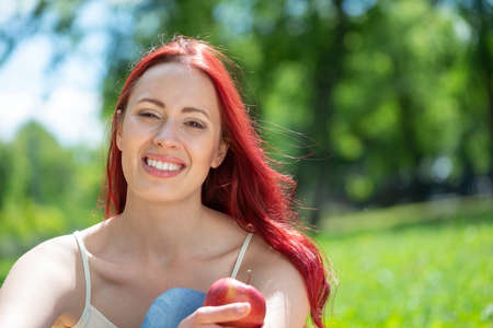 Portrait of a young attractive woman in the park. Smiling and happyの写真素材