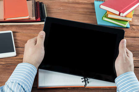 close-up of mens hands with a computer tablet. Businessman works in the office