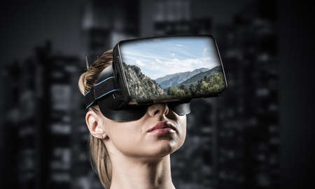 Young attractive woman in VR glasses. See nature through virtual realityの写真素材